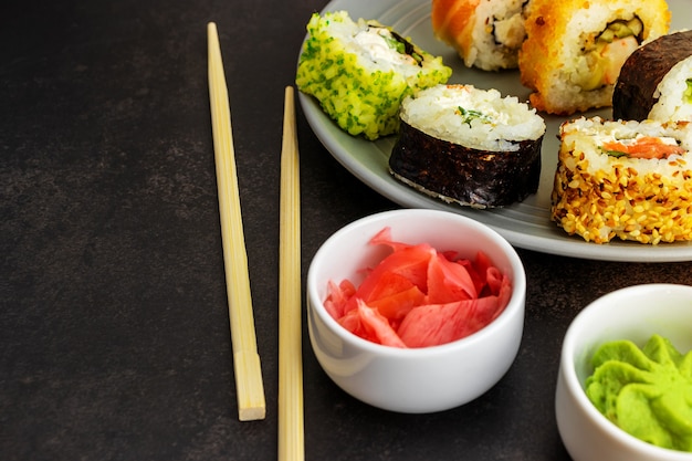 Rouleaux de sushi de différents types de maison en gros plan sur une surface sombre