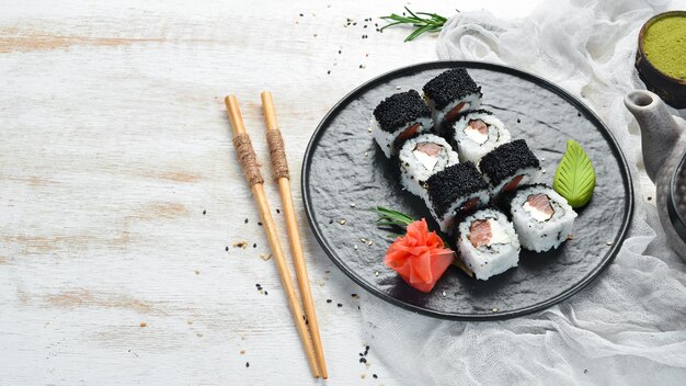 Rouleaux de sushi Fila Black avec saumon caviar noir et fromage Vue de dessus Espace libre pour votre texte