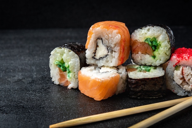Rouleaux de sushi sur fond noir. Nourriture japonaise.