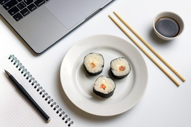 Photo rouleaux de sushi grignotant au travail. pause pour manger des sushis.