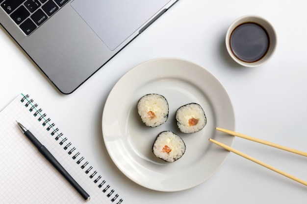 Rouleaux de sushi grignotant au travail. Pause pour manger des sushis.