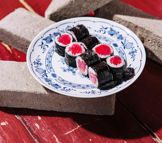 des rouleaux de sushi maki avec du thon à l'intérieur sur une brique de pierre