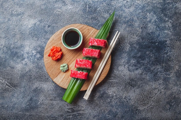 Des rouleaux de sushi sur planche de bois, fond en pierre, vue du haut