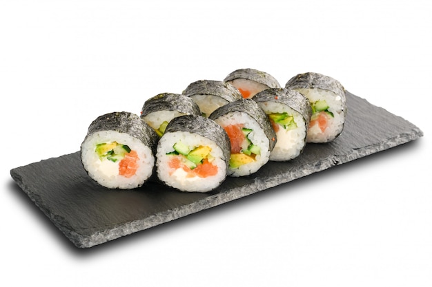 Photo rouleaux de sushi avec saumon, avocat, concombre et fromage à la crème à l'intérieur enveloppés dans une feuille de nori