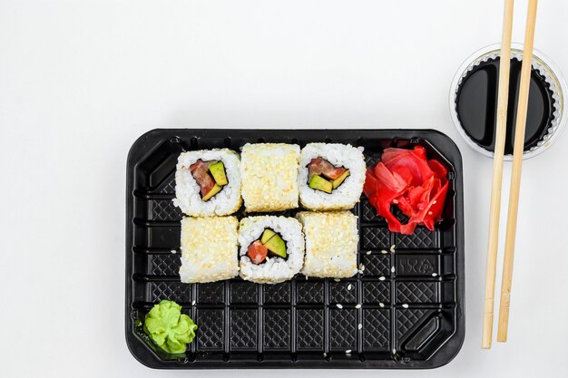 Rouleaux de Syake dans un ensemble de 6 pièces dans une boîte noire, avec gingembre, wasabi et sauce soja, restauration rapide, orientation horizontale, vue de dessus