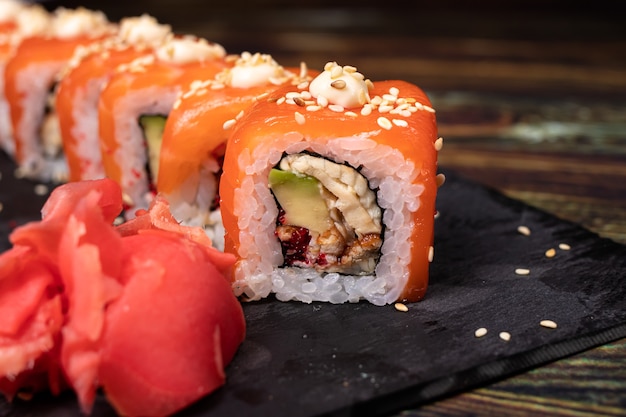 Rouleaux sur un tableau noir en pierre avec sauce wasabi sur fond blanc isoler.