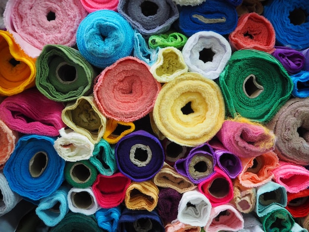 Des rouleaux de tissu colorés s'empilent dans le magasin.