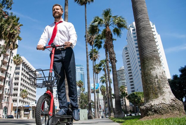 Rouler autour d'un avocat heureux en escooter sur le trottoir Faire du scooter électrique Transport électrique Transport personnel Vie moderne Mode de vie urbain