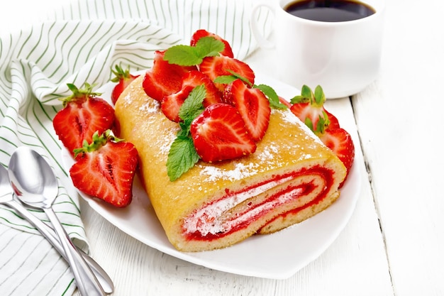 Rouler avec de la crème et des fraises dans une assiette à bord