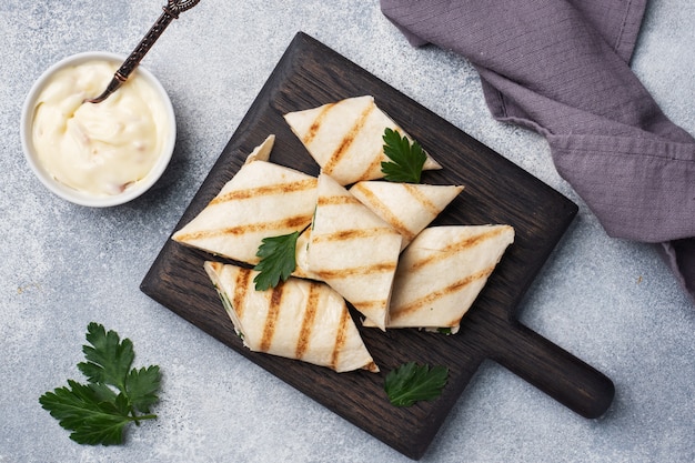 Rouler avec du fromage et des herbes. Pain pita grillé fourré. Salade de radis au concombre. Le concept d'un petit déjeuner sain.