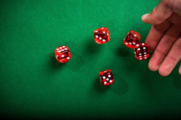 Rouler à la main des dés rouges sur la table