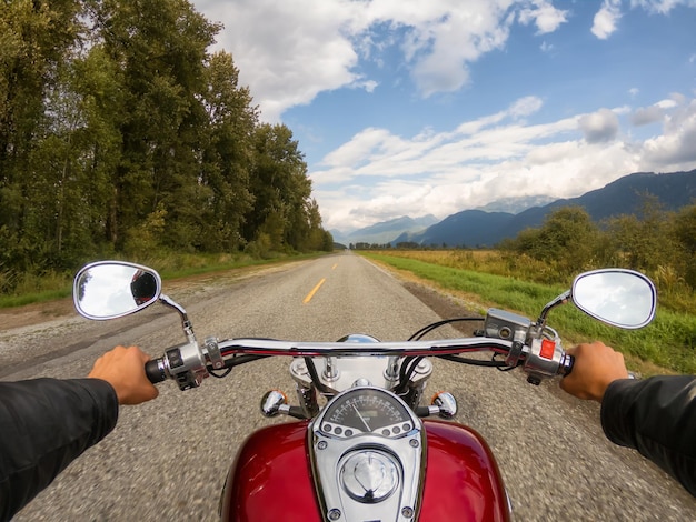 Rouler à moto sur une belle route panoramique entourée par les montagnes canadiennes