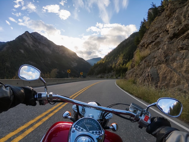 Rouler à moto sur une route panoramique entourée par les montagnes canadiennes