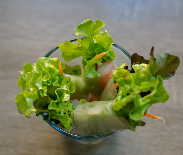 Photo rouler la salade dans une tasse en verre