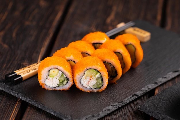 Rouler avec des sushis de poisson avec des baguettes concept de cuisine asiatique