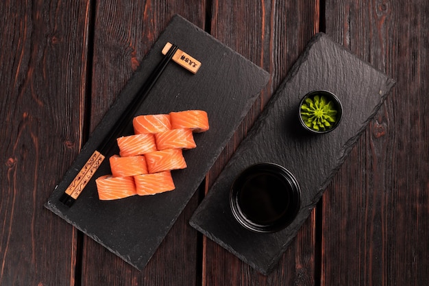 Rouler avec des sushis de poisson avec des baguettes concept de cuisine asiatique