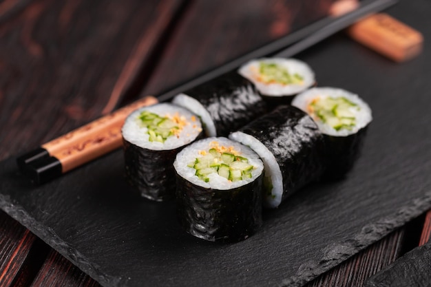 Rouler avec des sushis de poisson avec des baguettes concept de cuisine asiatique