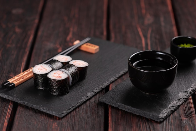 Rouler avec des sushis de poisson avec des baguettes concept de cuisine asiatique