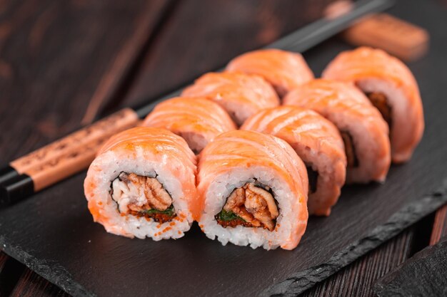 Rouler avec des sushis de poisson avec des baguettes concept de cuisine asiatique