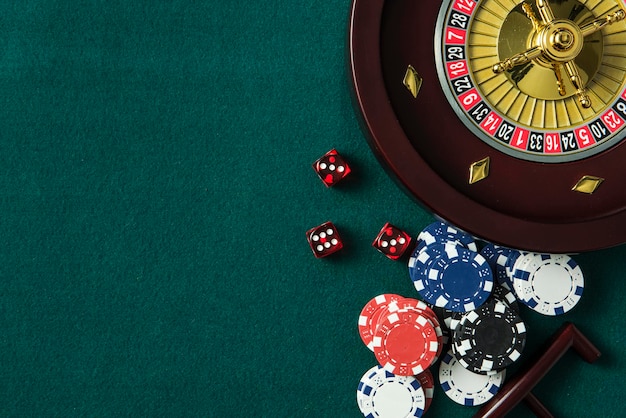 Roulette et jetons de casino sur fond de table verte