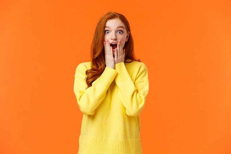 Photo une rousse impressionnée et sans voix a découvert des nouvelles impressionnantes, haletant, la mâchoire baissée étonnée