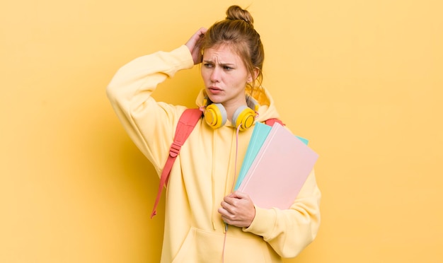 Rousse jolie fille souriant joyeusement et rêvassant ou doutant du concept étudiant