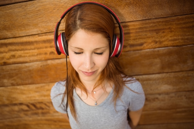 Rousse paisible en écoutant de la musique avec les yeux fermés