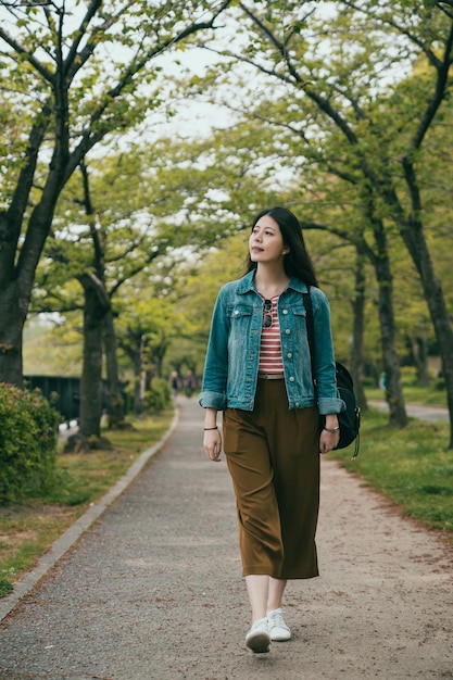 Routard femme marchant dans le parc du printemps