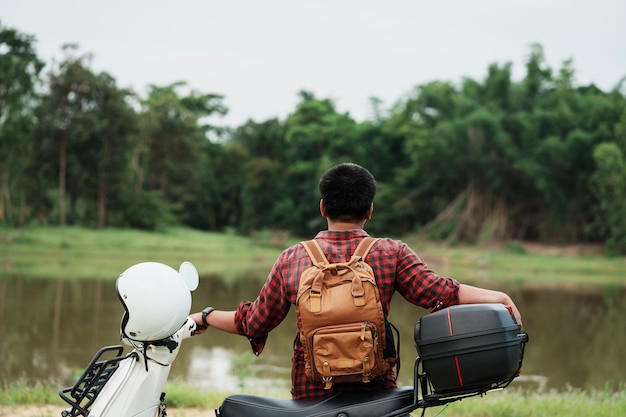 Routard hipster chevauchant un scooter sur la route Voyages en scooter vie lente en vacances temps de repos