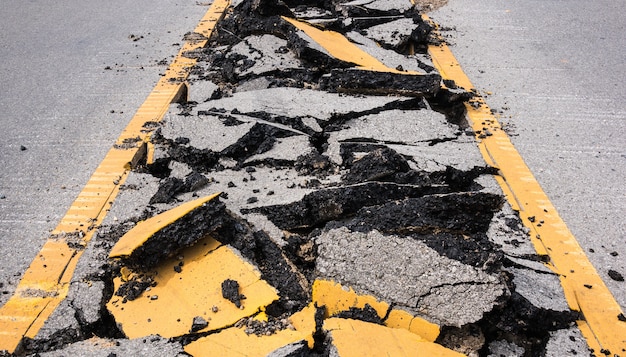 route d&#39;asphalte fissuré avec des lignes de marquage