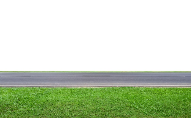 Une route d'asphalte vide traversant un champ d'herbe verte