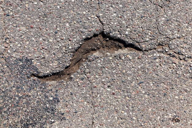 Une route asphaltée avec beaucoup de trous et de dégâts