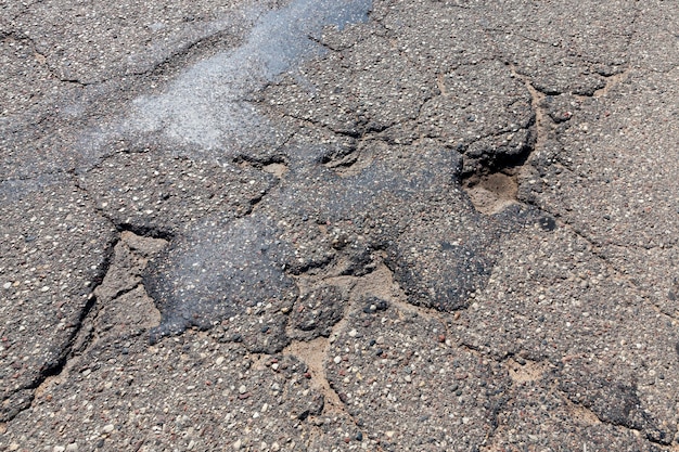 Une route asphaltée avec beaucoup de trous et de dégâts