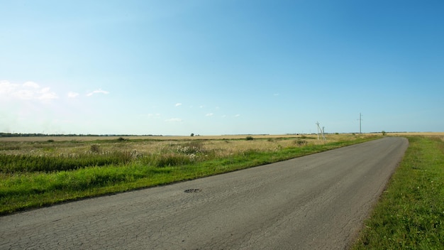 Route asphaltée entre deux champs