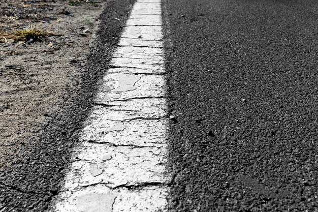 Route asphaltée noire et lignes de démarcation blanches.