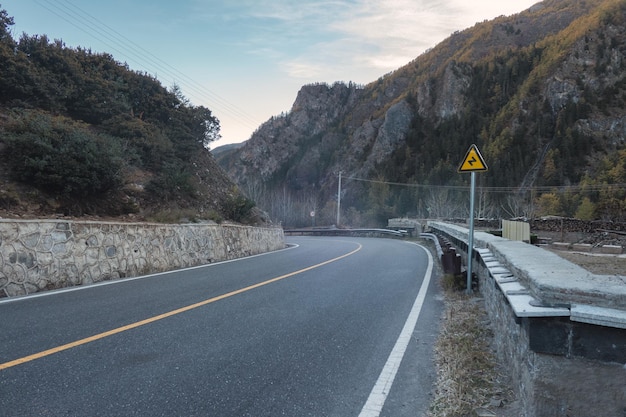 Route asphaltée avec panneaux de signalisation dans la vallée