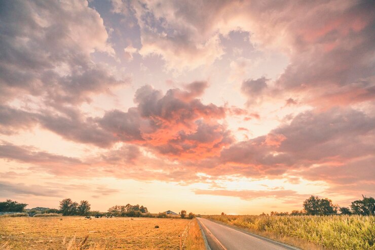 Photo route au milieu d'un champ contre le ciel au coucher du soleil