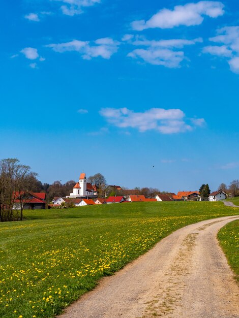 Photo la route au milieu du champ et des bâtiments contre le ciel