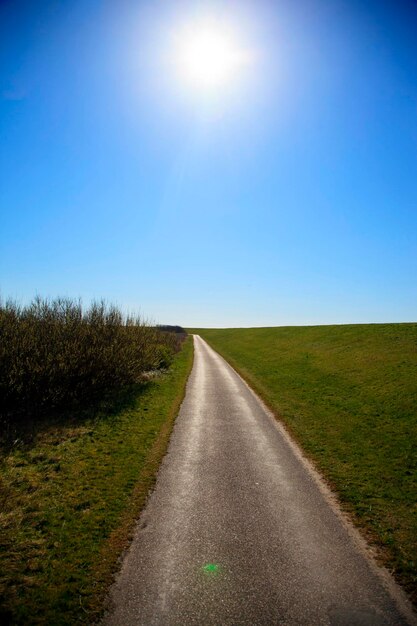 Photo la route au milieu du champ contre le ciel