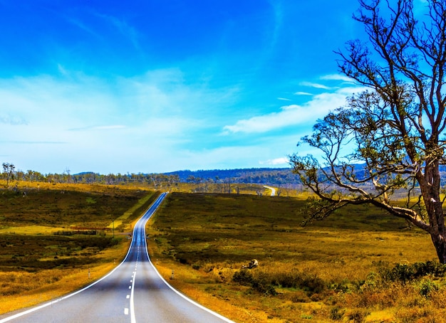 Photo la route au milieu du paysage contre le ciel