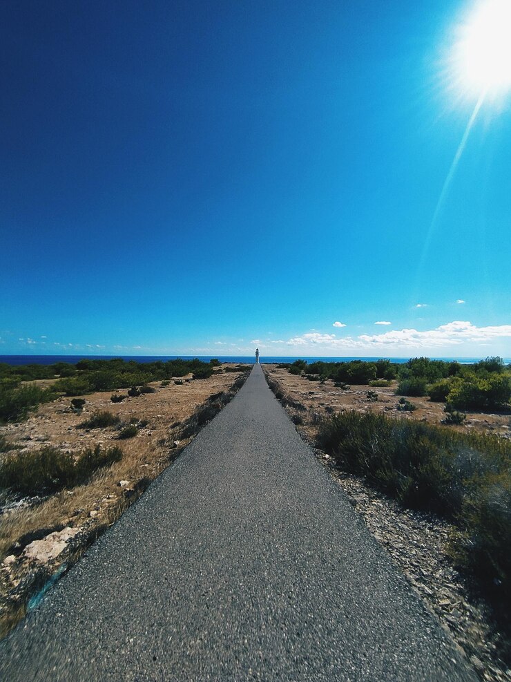 Photo une route au milieu d'un paysage contre un ciel bleu clair