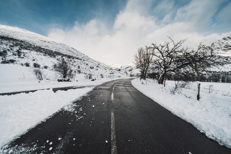 Photo une route au milieu d'un paysage couvert de neige contre le ciel