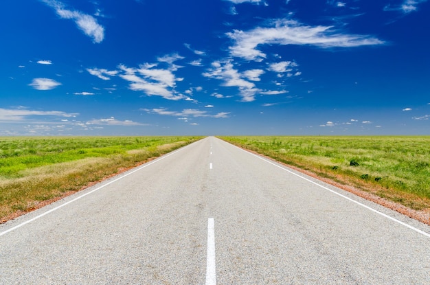 Une route au milieu d'un paysage vert contre un ciel bleu
