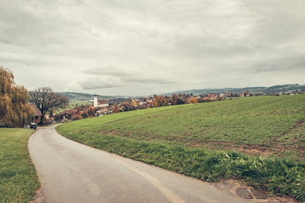 Photo une route au milieu d'un paysage vert contre le ciel