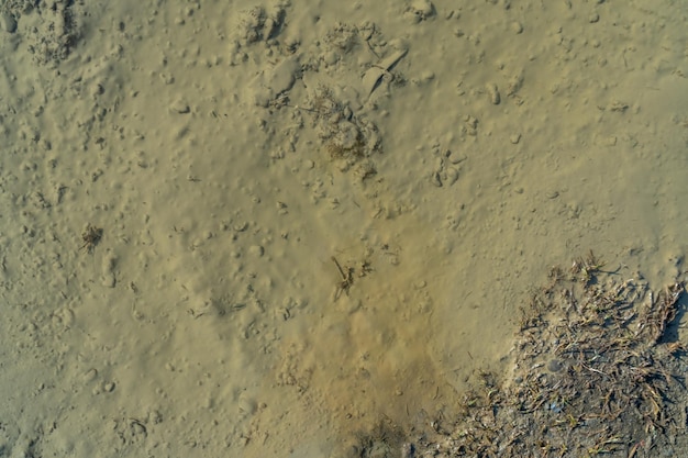 Une route cahoteuse de gravier humide après la texture de la pluie