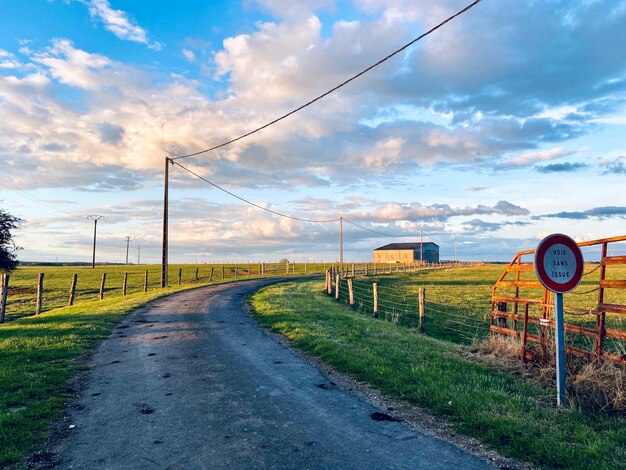 Photo une route de campagne au milieu d'un champ contre le ciel