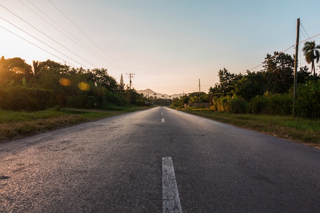 Photo route de campagne avec un beau coucher de soleil