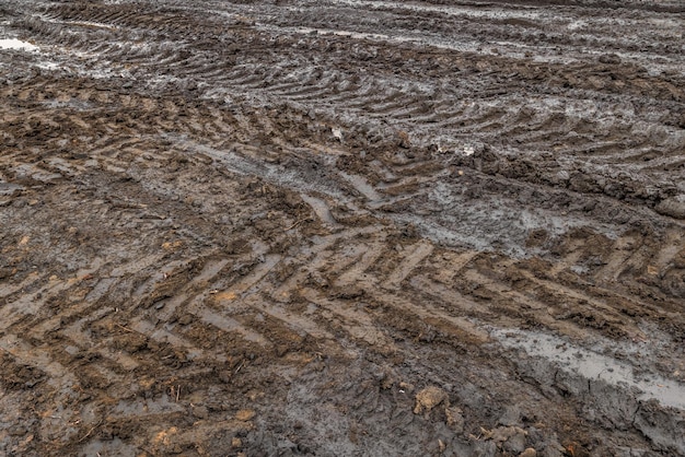 Une route de campagne rurale cassée après la pluie Flaques d'eau après la pluie sur un chemin de terre Sol argileux et flaques d'eau à la lumière du jour nuageux après la saison d'automne de la pluie