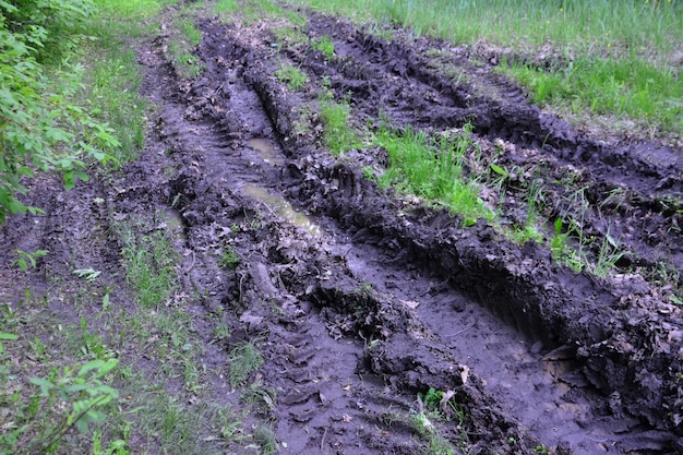 route de campagne sale avec de la boue et des pistes de tracteur isolé, gros plan