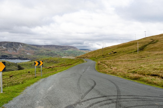 Photo une route de campagne avec des traces de pneus laissées sur le côté.